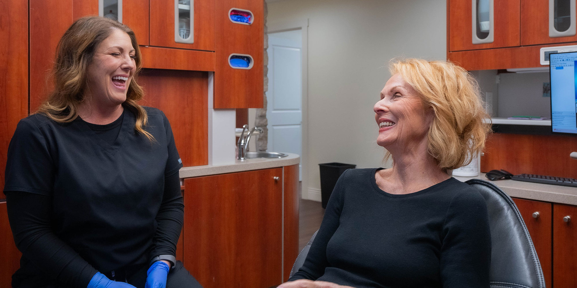 team member and patient smiling and laughing together