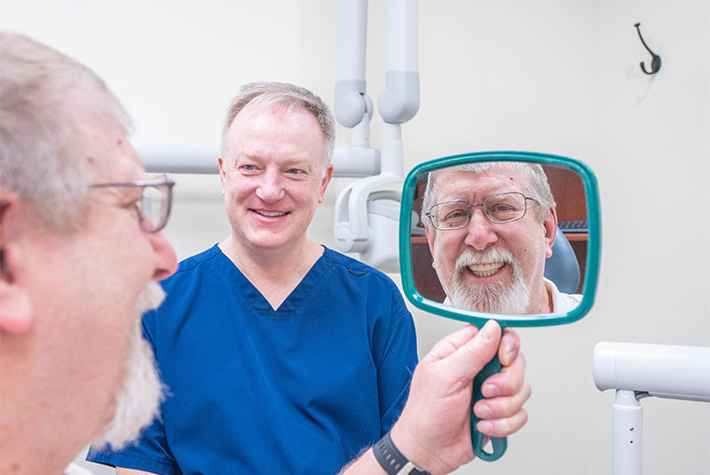 patient looking into mirror after invisalign treatment