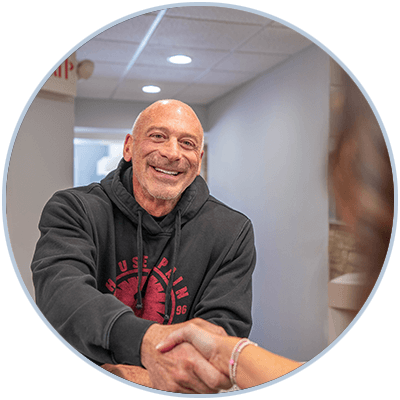 patient shaking hands with team member smiling